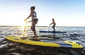 Couple skimming across the water using pedal boats.
